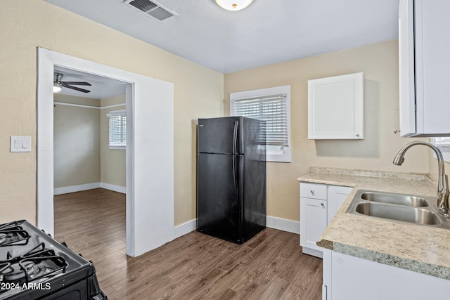 kitchen featuring white cabinetry, sink, black appliances, and plenty of natural light