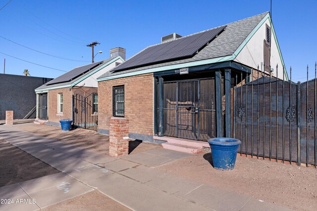 back of property featuring solar panels