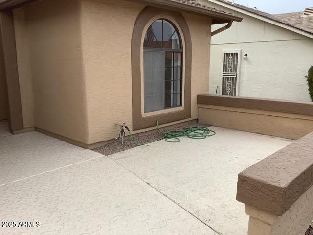 view of exterior entry with a patio area