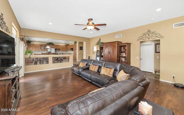 living room with ceiling fan and dark hardwood / wood-style floors