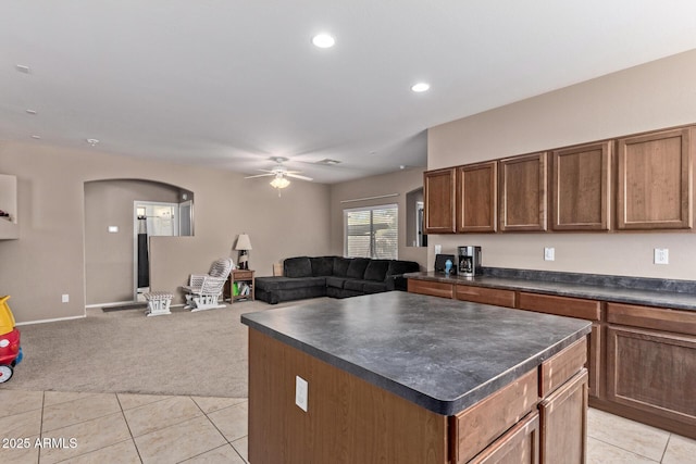 kitchen with a kitchen island, ceiling fan, and light carpet