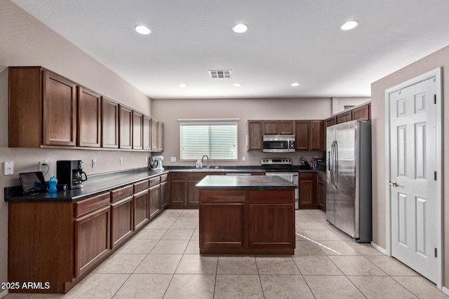 kitchen with dark brown cabinetry, a center island, stainless steel appliances, sink, and light tile patterned floors