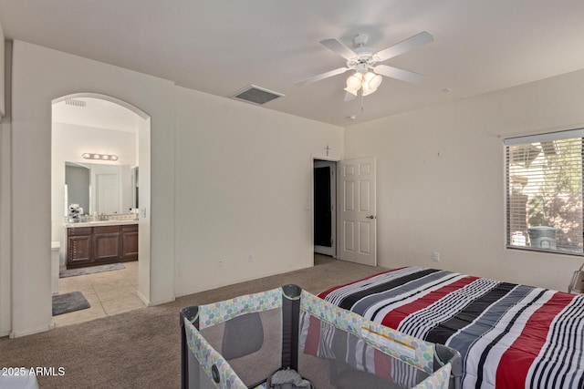 carpeted bedroom with sink, connected bathroom, and ceiling fan