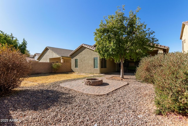 rear view of house with a patio area and a fire pit