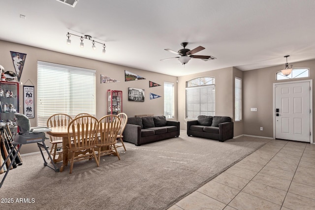 carpeted living room with ceiling fan and plenty of natural light