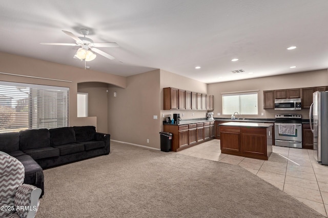 tiled living room featuring sink and ceiling fan