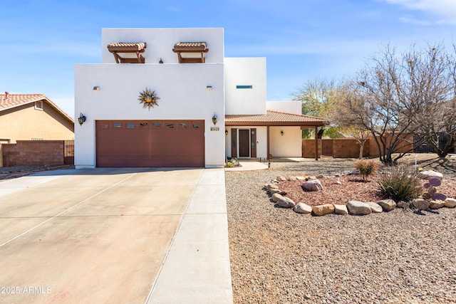 view of front of house featuring a garage, a tile roof, fence, driveway, and stucco siding