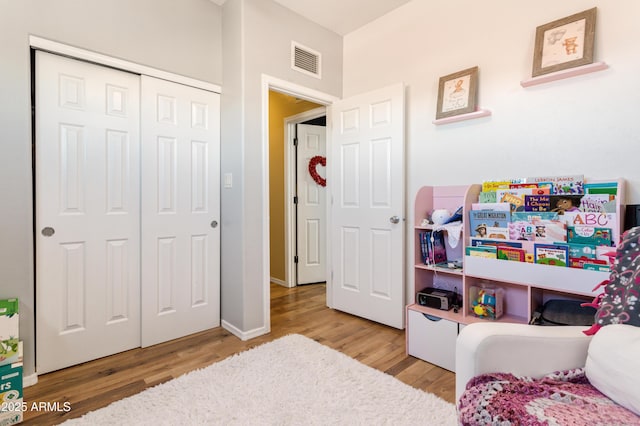 bedroom featuring a closet, visible vents, and wood finished floors