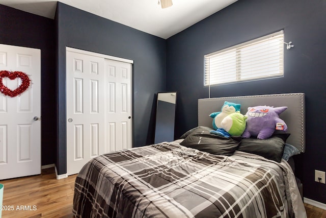 bedroom with ceiling fan, a closet, wood finished floors, and baseboards