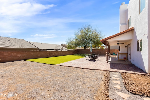 view of yard with a patio area, a fenced backyard, and a ceiling fan