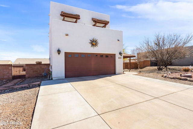 exterior space featuring a garage, fence, and stucco siding