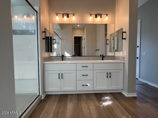 bathroom featuring hardwood / wood-style floors, vanity, and a shower with door