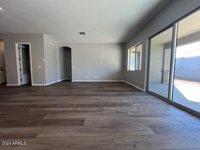 unfurnished room with dark wood-type flooring