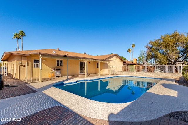 view of pool with a grill and a patio