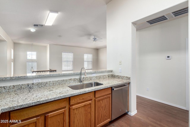 kitchen featuring light stone counters, a sink, visible vents, and stainless steel dishwasher