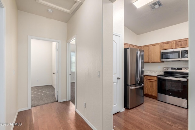 kitchen featuring visible vents, baseboards, light countertops, light wood-style floors, and stainless steel appliances