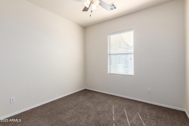 carpeted spare room featuring visible vents, baseboards, and a ceiling fan