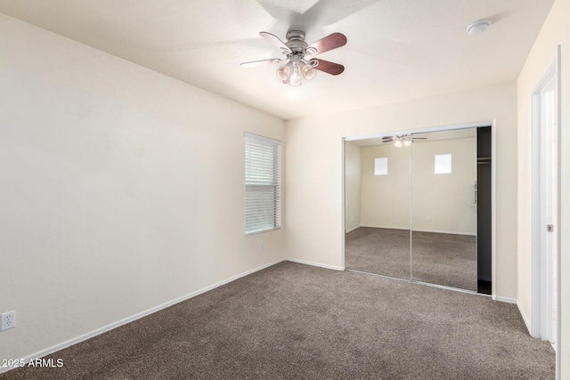 unfurnished bedroom featuring a closet, baseboards, carpet, and ceiling fan