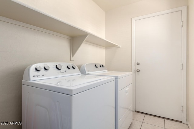 clothes washing area featuring washer and clothes dryer, laundry area, and light tile patterned floors