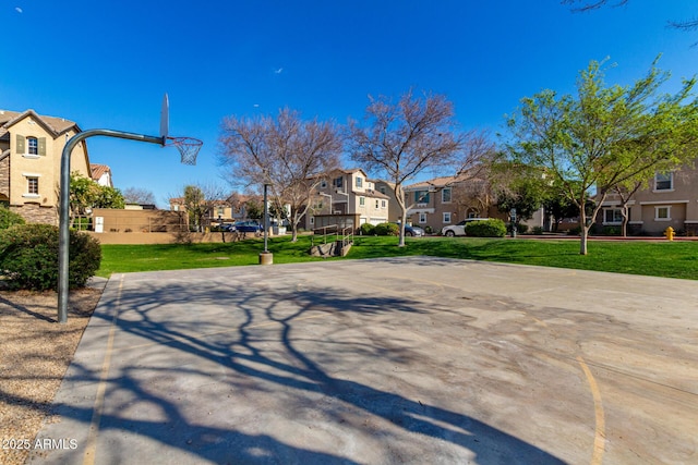 exterior space featuring a residential view, a lawn, and community basketball court