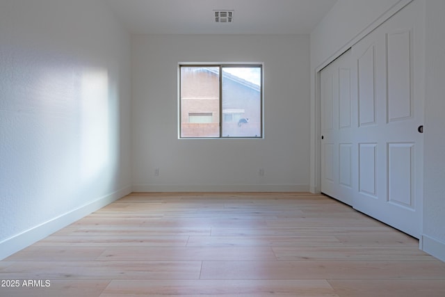 unfurnished bedroom featuring a closet and light hardwood / wood-style flooring