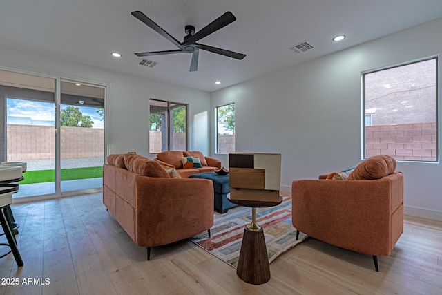 living room featuring ceiling fan and light hardwood / wood-style flooring