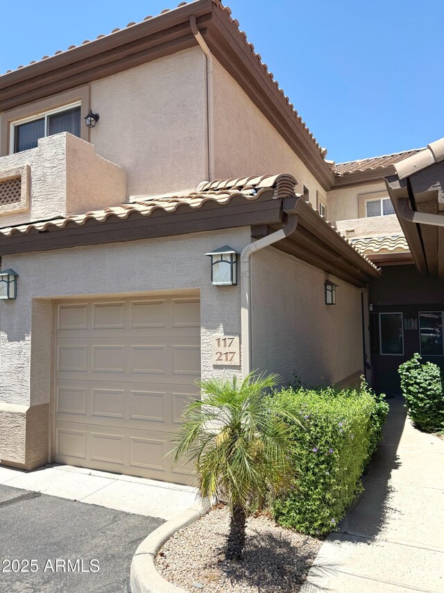 6535 E Superstition Springs Blvd Unit 217, Mesa, AZ 85206 - view of property exterior featuring a tile roof, stucco siding, and a garage