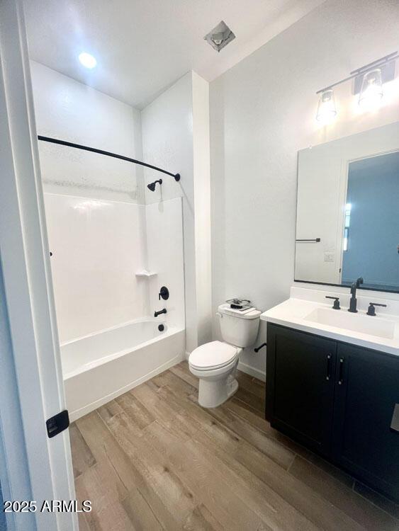 full bathroom featuring vanity, shower / tub combination, hardwood / wood-style floors, and toilet