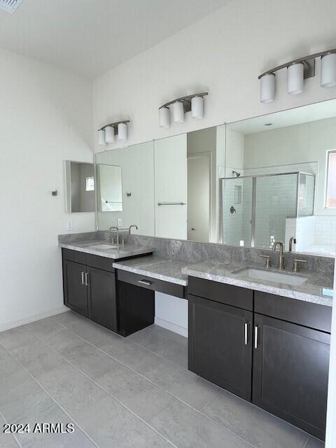 bathroom featuring vanity, tile patterned floors, and a shower with shower door