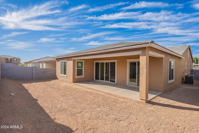 back of property with central AC unit and a patio area