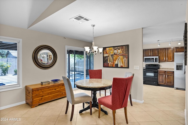 dining space featuring light tile patterned floors, baseboards, visible vents, and a chandelier