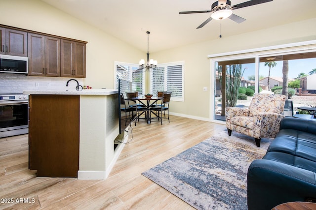 6831 S Coral Gable Dr, Chandler, AZ 85249 - living area featuring healthy amount of natural light, vaulted ceiling, a ceiling fan, light wood-type flooring, and a chandelier