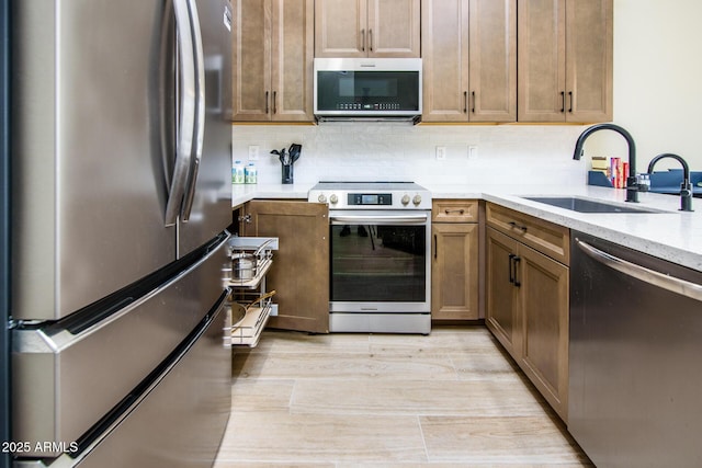 6831 S Coral Gable Dr, Chandler, AZ 85249 - kitchen featuring appliances with stainless steel finishes, a sink, tasteful backsplash, light stone countertops, and light wood-style floors