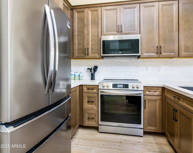 6831 S Coral Gable Dr, Chandler, AZ 85249 - kitchen with stainless steel appliances, backsplash, and brown cabinetry