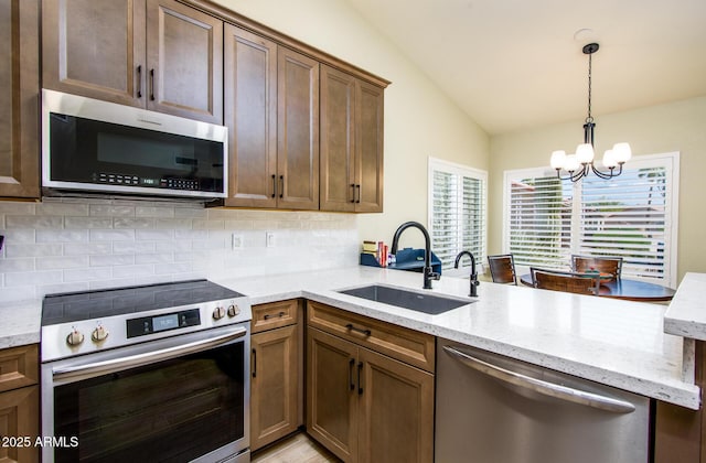 6831 S Coral Gable Dr, Chandler, AZ 85249 - kitchen with appliances with stainless steel finishes, a chandelier, a sink, vaulted ceiling, and decorative backsplash