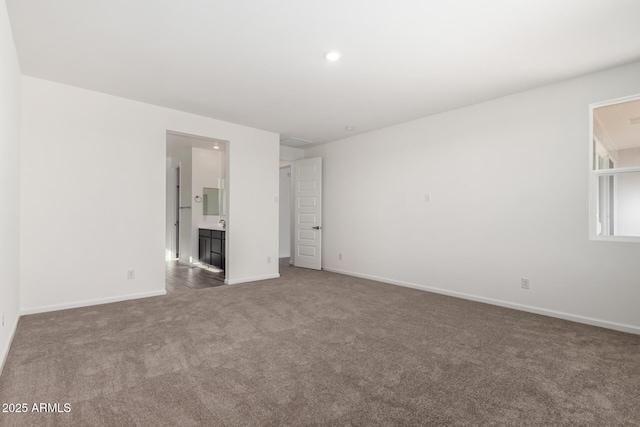 unfurnished room with dark colored carpet