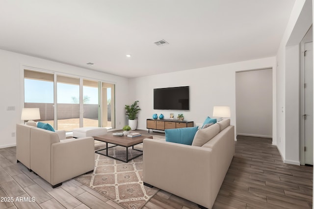 living room featuring light wood-style flooring, visible vents, and baseboards