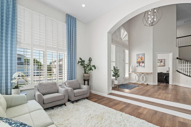 3665 S Jojoba Way, Chandler, AZ 85248 - living room featuring arched walkways, a chandelier, wood finished floors, recessed lighting, and a towering ceiling