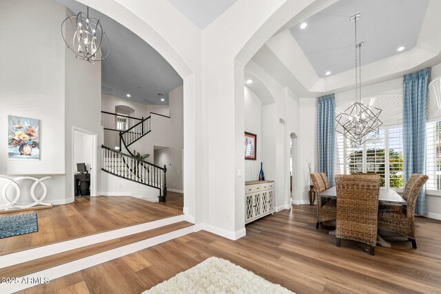 3665 S Jojoba Way, Chandler, AZ 85248 - dining area featuring a chandelier, arched walkways, stairway, wood finished floors, and recessed lighting