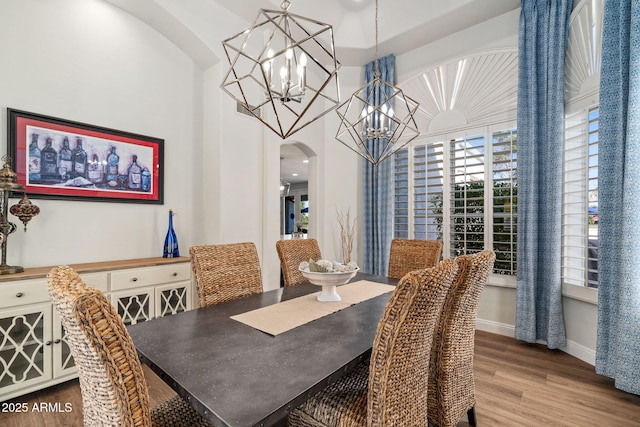 3665 S Jojoba Way, Chandler, AZ 85248 - dining area featuring arched walkways, a chandelier, wood finished floors, and baseboards