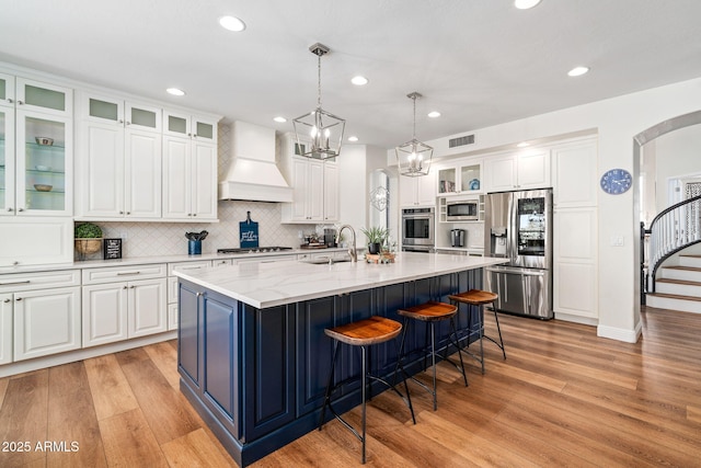 3665 S Jojoba Way, Chandler, AZ 85248 - kitchen featuring appliances with stainless steel finishes, custom range hood, light wood-style floors, white cabinets, and recessed lighting