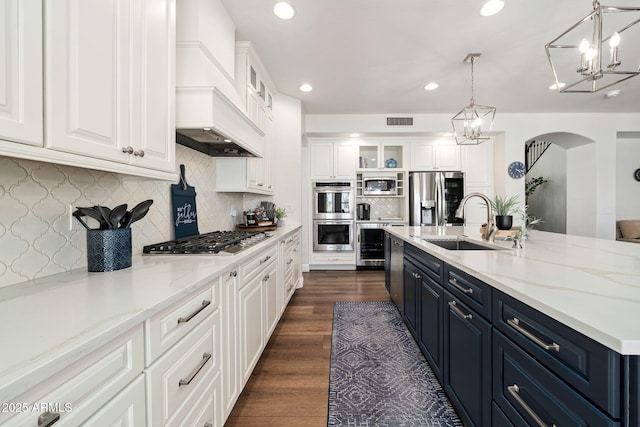 3665 S Jojoba Way, Chandler, AZ 85248 - kitchen featuring stainless steel appliances, custom range hood, a chandelier, arched walkways, and a sink