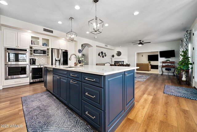 3665 S Jojoba Way, Chandler, AZ 85248 - kitchen with stainless steel appliances, beverage cooler, a ceiling fan, blue cabinets, and a sink