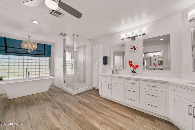 3665 S Jojoba Way, Chandler, AZ 85248 - bathroom with a shower stall, ceiling fan, double vanity, wood finished floors, and a freestanding tub