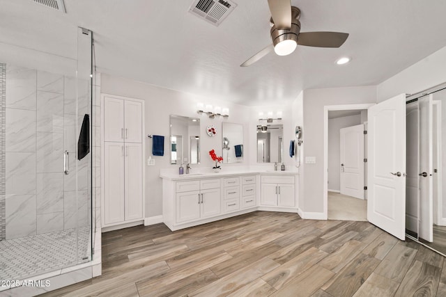 3665 S Jojoba Way, Chandler, AZ 85248 - bathroom featuring ceiling fan, a stall shower, wood finished floors, double vanity, and baseboards