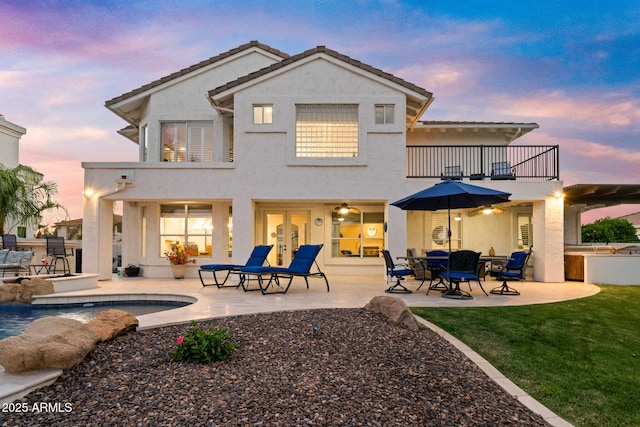3665 S Jojoba Way, Chandler, AZ 85248 - back of property at dusk with a balcony, a patio area, stucco siding, and an outdoor pool