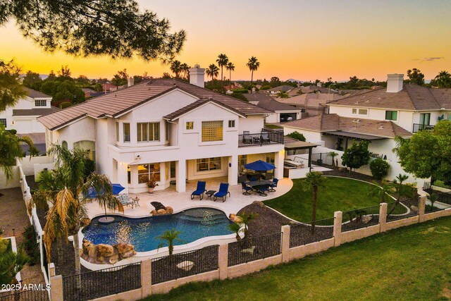 3665 S Jojoba Way, Chandler, AZ 85248 - back of property at dusk with a balcony, a patio, stucco siding, a tiled roof, and outdoor dining area
