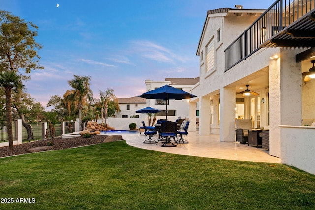 3665 S Jojoba Way, Chandler, AZ 85248 - yard at dusk featuring a balcony, a patio area, and ceiling fan