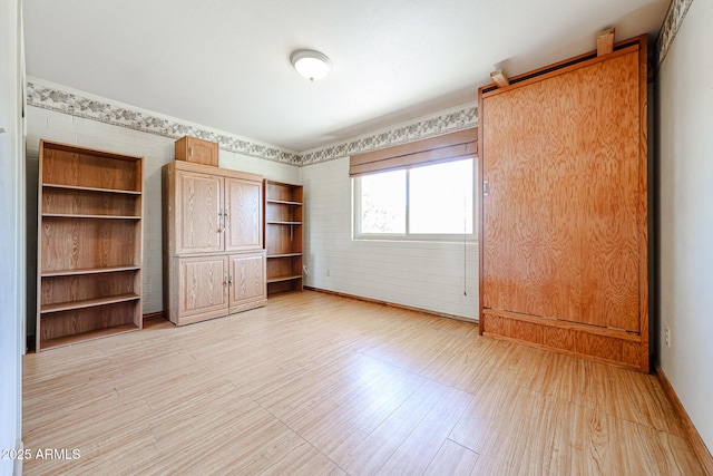 unfurnished bedroom featuring baseboards and light wood finished floors