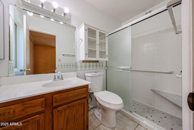 bathroom with tile patterned flooring, a shower stall, toilet, and vanity